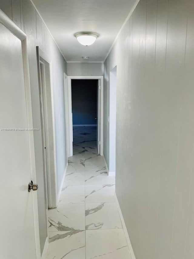 hall featuring wooden walls and crown molding