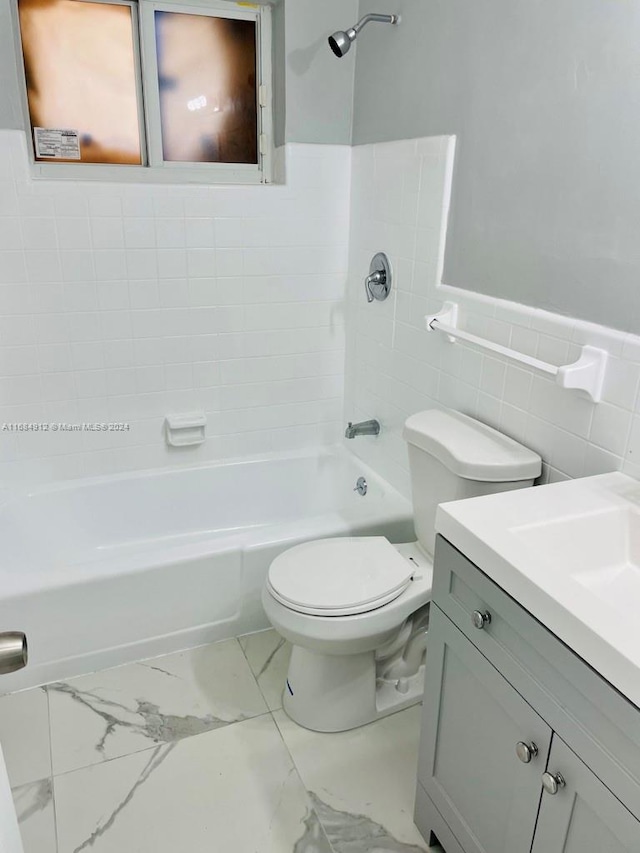 full bathroom with vanity, toilet, tile walls, and bathing tub / shower combination