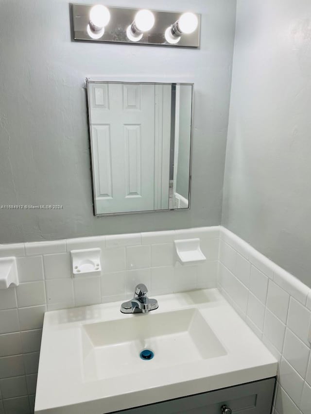 bathroom with vanity and tile walls