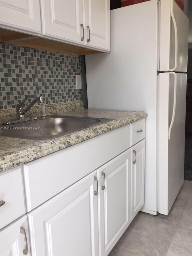 kitchen with sink, white cabinetry, and tasteful backsplash