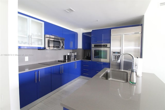 kitchen with blue cabinetry, sink, and appliances with stainless steel finishes