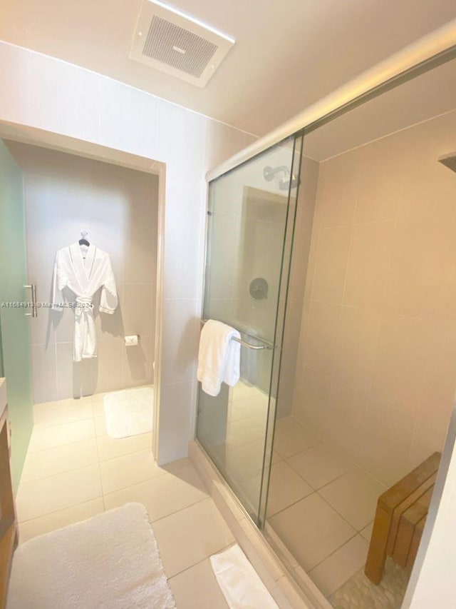 bathroom featuring tile patterned floors and a shower with shower door