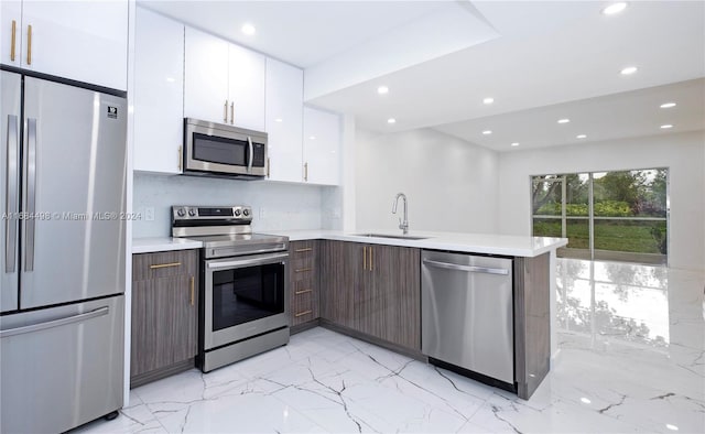 kitchen with white cabinetry, stainless steel appliances, dark brown cabinetry, and sink