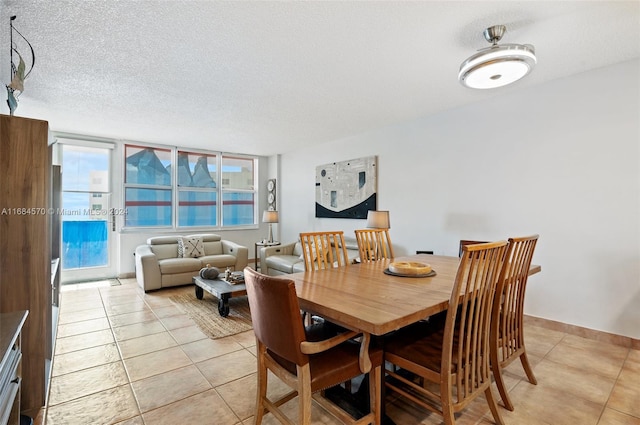 dining room with a textured ceiling and light tile patterned floors