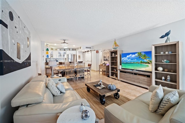 living room featuring tile patterned floors, a textured ceiling, and ceiling fan