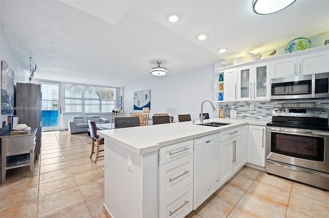 kitchen featuring white cabinets, stainless steel appliances, sink, and light tile patterned floors