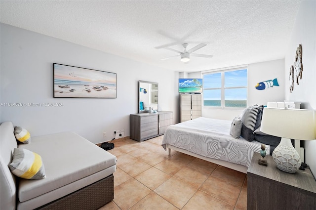 tiled bedroom with a textured ceiling and ceiling fan