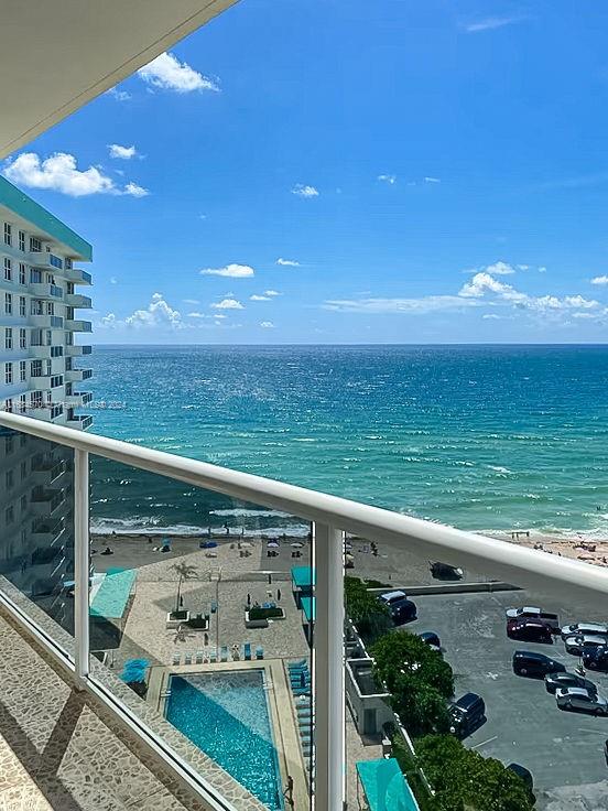 balcony featuring a water view and a view of the beach