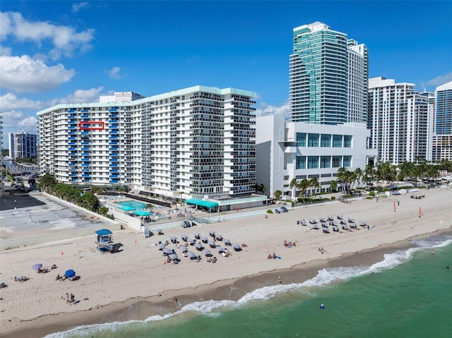 view of property with a water view and a beach view