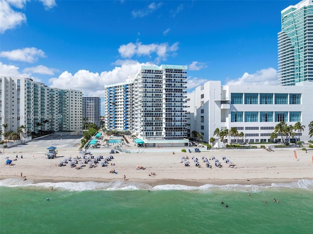 view of building exterior featuring a water view and a view of the beach