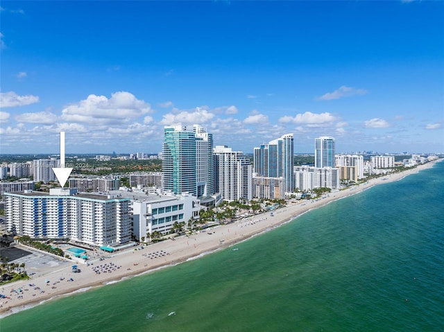 birds eye view of property with a water view and a beach view