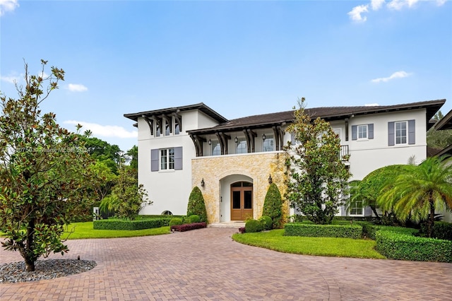 view of front facade featuring a front lawn and a balcony