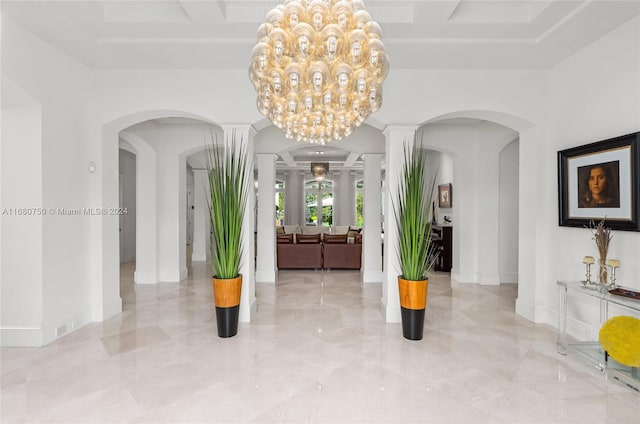 entrance foyer featuring a notable chandelier and decorative columns