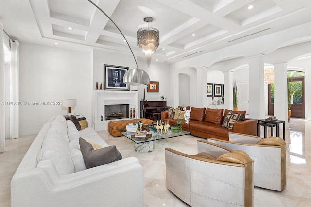 living room with a notable chandelier, beamed ceiling, coffered ceiling, and decorative columns