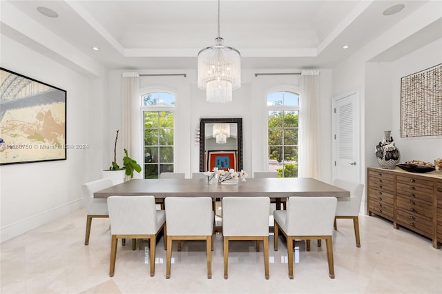 dining room featuring a chandelier, a raised ceiling, and a wealth of natural light