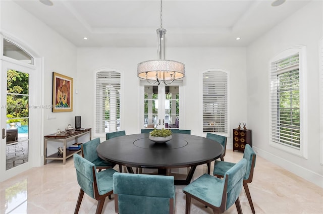 dining space featuring french doors, an inviting chandelier, and a raised ceiling