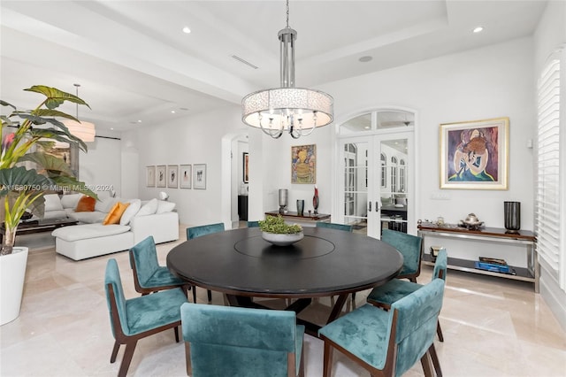 dining room with a tray ceiling and an inviting chandelier