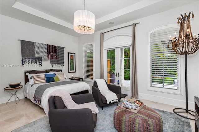 bedroom with a tray ceiling, multiple windows, and a chandelier