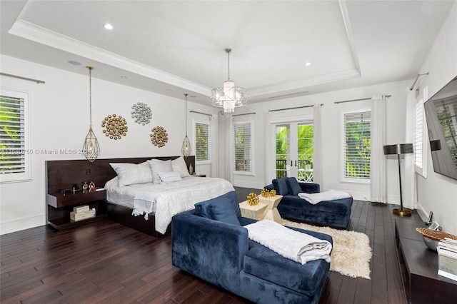 bedroom with french doors, a tray ceiling, crown molding, and dark hardwood / wood-style flooring