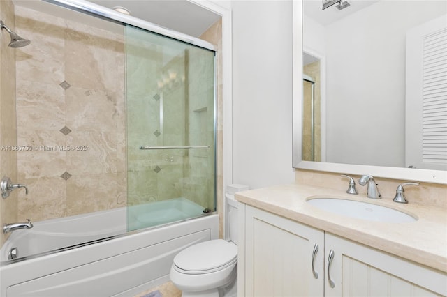 full bathroom featuring vanity, enclosed tub / shower combo, and toilet