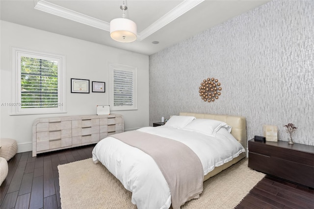 bedroom with crown molding, dark hardwood / wood-style floors, and a tray ceiling