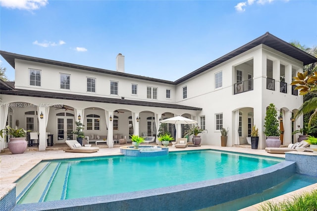 back of house featuring a swimming pool with hot tub, a patio area, french doors, and ceiling fan