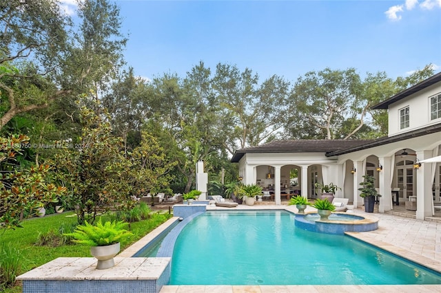 view of pool featuring a patio area and an in ground hot tub