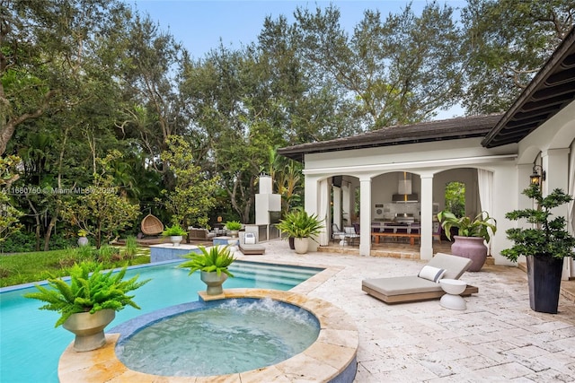 view of swimming pool with an in ground hot tub and a patio area