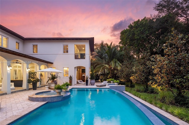 pool at dusk with a patio