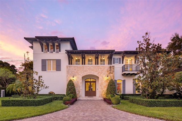 mediterranean / spanish home featuring french doors, a yard, and a balcony