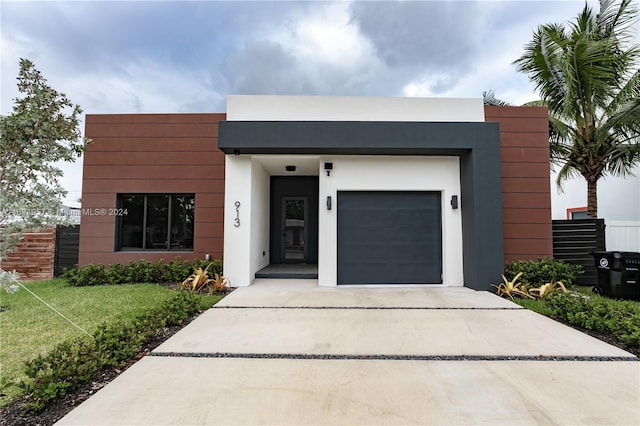 contemporary home with a front yard and a garage