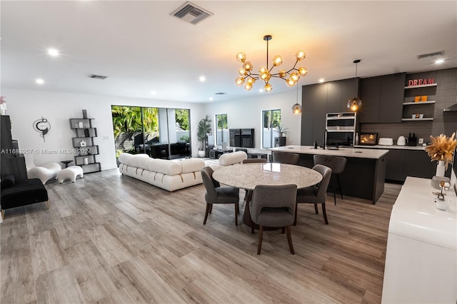 dining room featuring a notable chandelier and light wood-type flooring