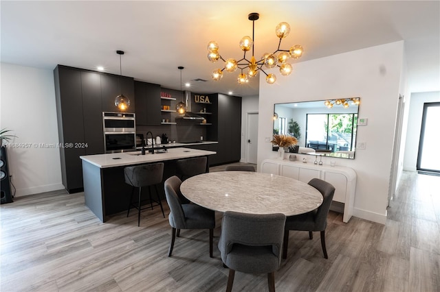 dining space featuring light hardwood / wood-style floors, a notable chandelier, and sink