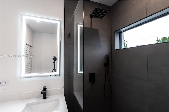 bathroom with vanity and tiled shower