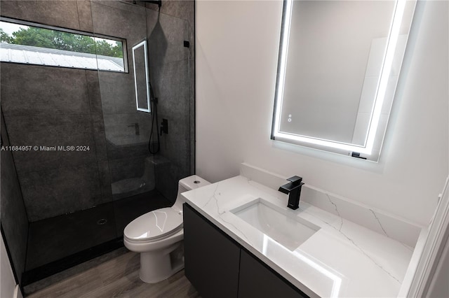 bathroom with toilet, walk in shower, vanity, and wood-type flooring