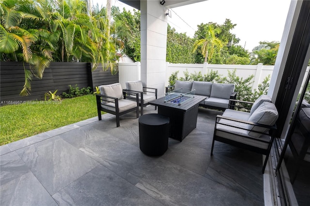 view of patio with an outdoor living space with a fire pit