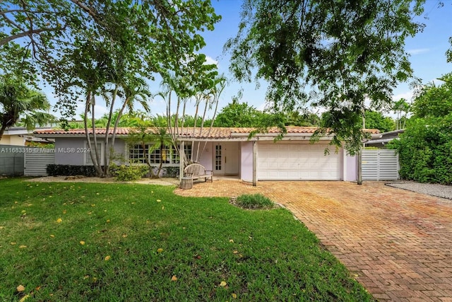 ranch-style home featuring a front yard and a garage