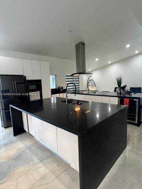 kitchen featuring a spacious island, island exhaust hood, sink, black appliances, and white cabinets