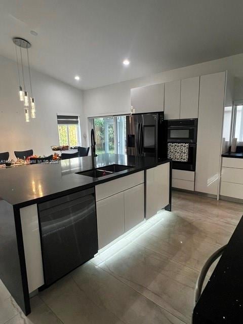 kitchen with white cabinets, an island with sink, black appliances, sink, and decorative light fixtures