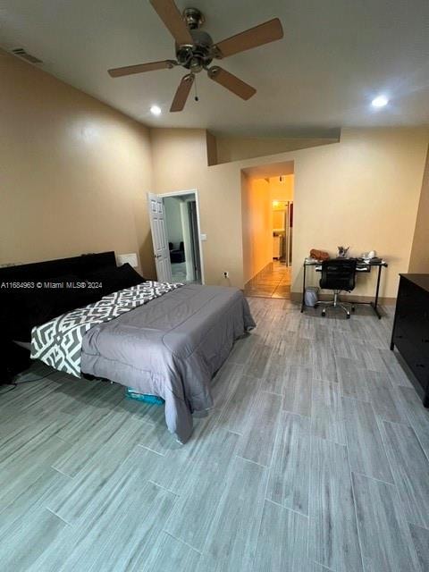 bedroom featuring lofted ceiling, light wood-type flooring, and ceiling fan