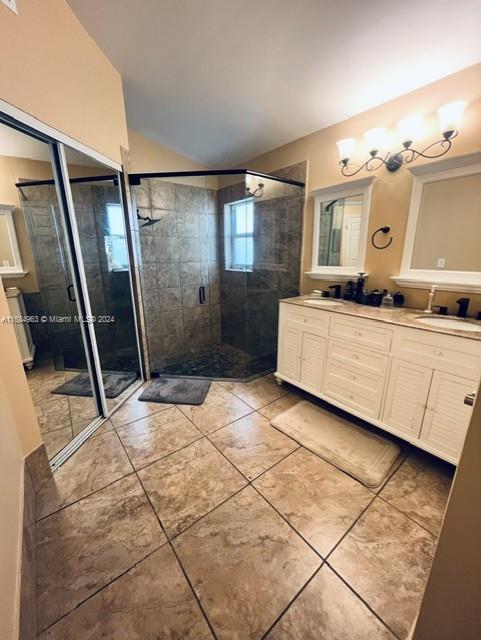 bathroom featuring vanity, tile patterned floors, and a shower with door