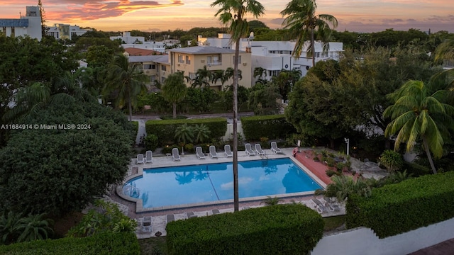 pool at dusk with a patio area