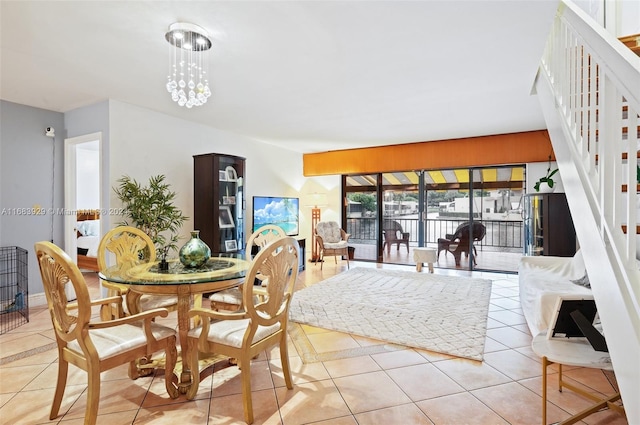 dining area with light tile patterned floors and an inviting chandelier