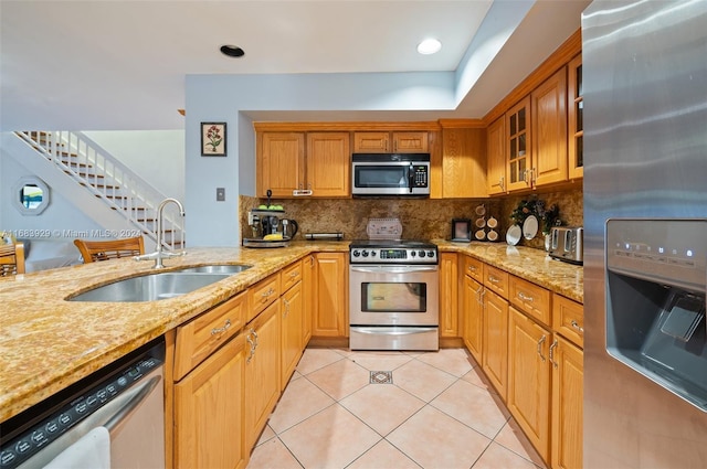15442 Kippford Ct, Miami Lakes, FL 33014 - kitchen with decorative backsplash, appliances with stainless steel finishes, a sink, light tile patterned floors, and light stone counters