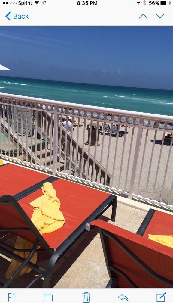 balcony featuring a water view and a view of the beach