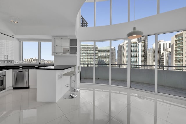 kitchen with white cabinets, light tile patterned floors, and appliances with stainless steel finishes