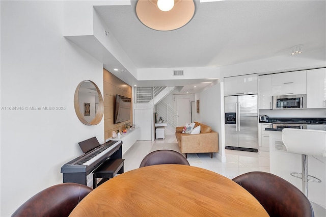 dining area featuring light tile patterned floors, recessed lighting, visible vents, and stairs