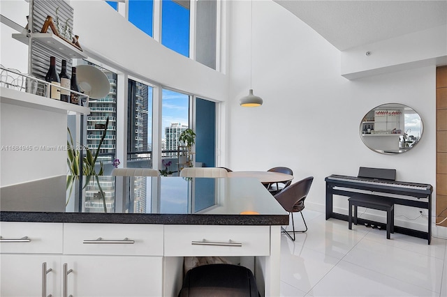 kitchen with dark countertops, white cabinetry, open shelves, and light tile patterned floors