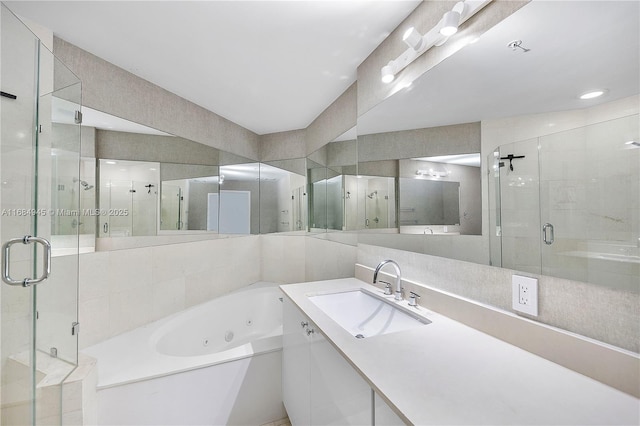 full bathroom with a whirlpool tub, a stall shower, and vanity