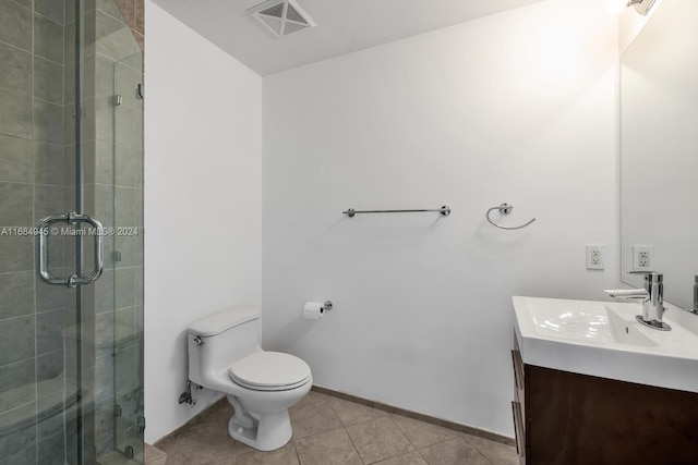 bathroom featuring tile patterned flooring, vanity, toilet, and walk in shower